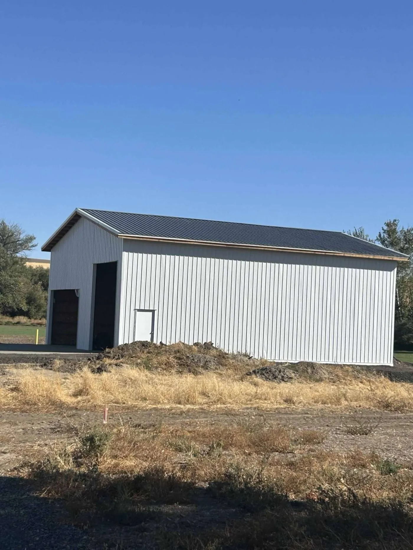 Finished building with dark metal roofing and vertical panel siding