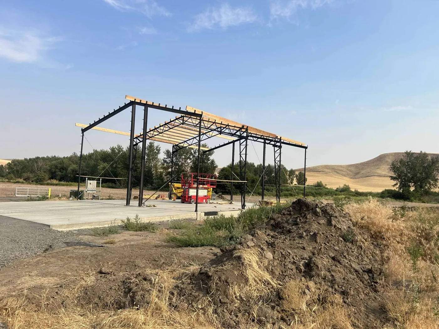 Steel building frame on a freshly poured concrete slab