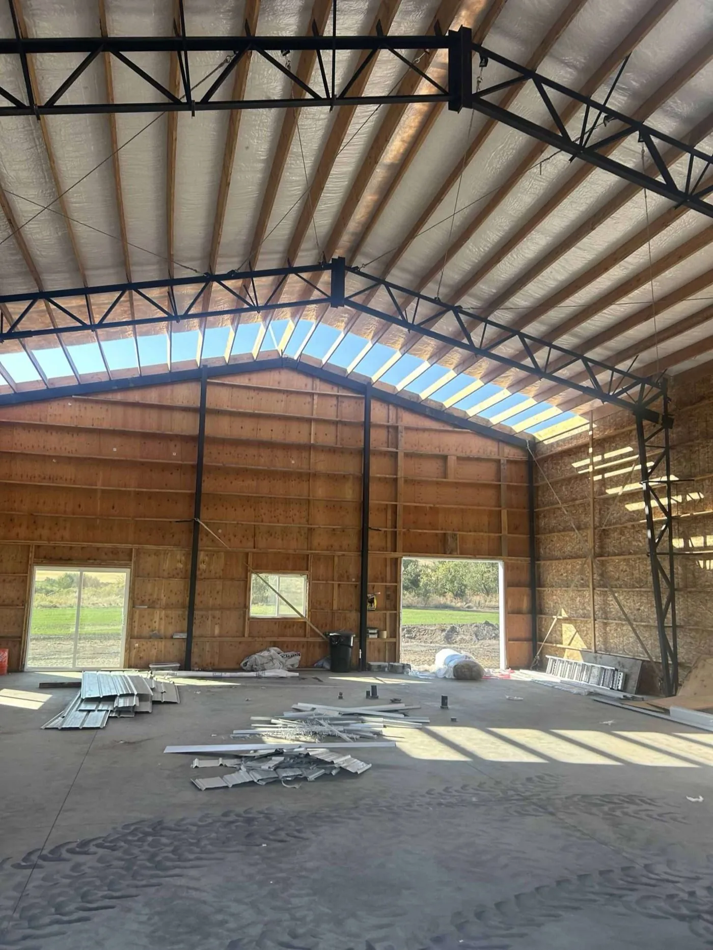 Interior of a steel-frame building showing steel truss bracing and skylight panels